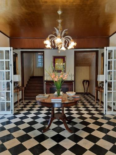 a living room with a table and a checkered floor at Abbotsford Prasada Bhawan in Nainital