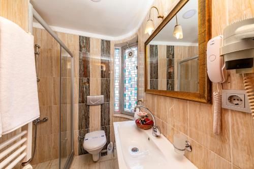 a bathroom with a sink and a toilet and a mirror at Santa Ottoman Hotel in Istanbul