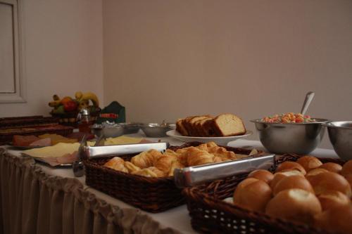 a table topped with baskets of bread and other foods at Hotel Escorial in Piriápolis