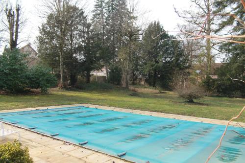a large swimming pool with blue water in a yard at La Levriere d'Arc les Gray Chambre D'hotes in Arc