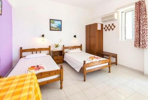 Un dormitorio con dos camas y una ventana. en Evi Apartments And Studios, en Theologos