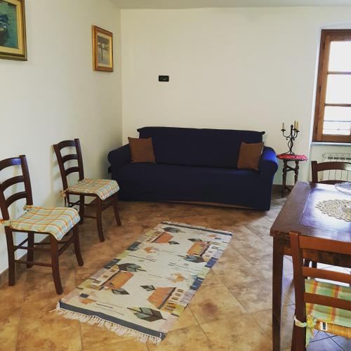 a living room with a blue couch and chairs at La casa di Gina in Sassello