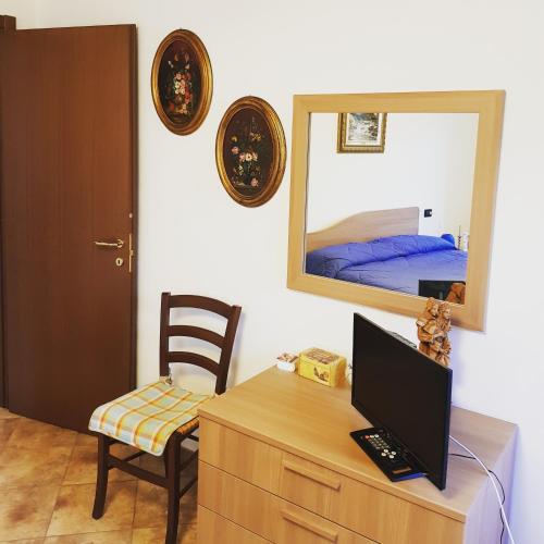 a room with a desk with a computer and a mirror at La casa di Gina in Sassello
