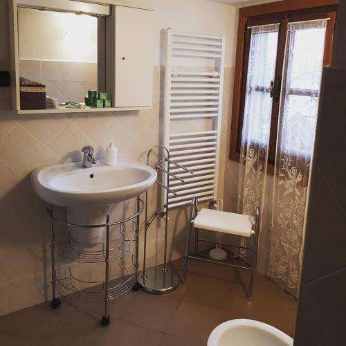 a bathroom with a sink and a toilet and a mirror at La casa di Gina in Sassello