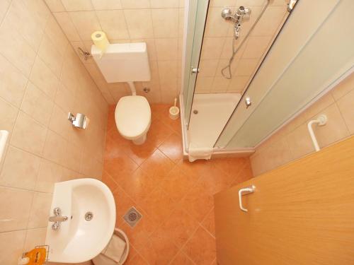 a bathroom with a toilet and a sink and a mirror at Apartments Drandic in Fažana
