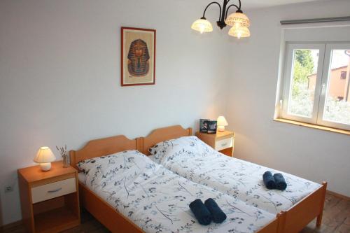 a bedroom with a bed with two shoes on it at Apartments Drandic in Fažana
