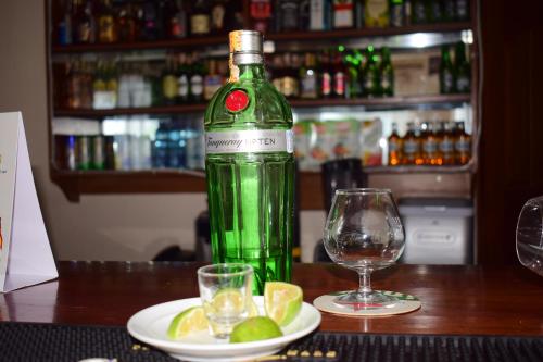 a green bottle of wine next to a plate of lime slices at Meru Slopes Hotel in Meru
