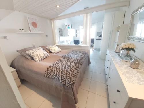 Dormitorio blanco con cama y barra en Central Apartment With Sea Views, en Mogán