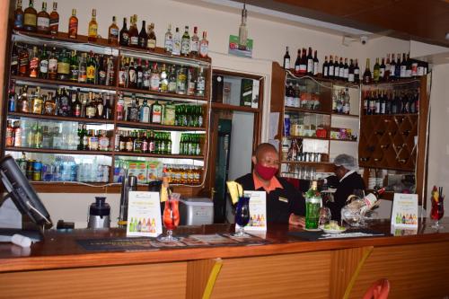 a man sitting at a bar behind a counter at Meru Slopes Hotel in Meru