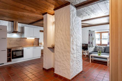 a kitchen with white cabinets and a living room at Gästehaus Prugger by Schladmingurlaub in Ramsau am Dachstein