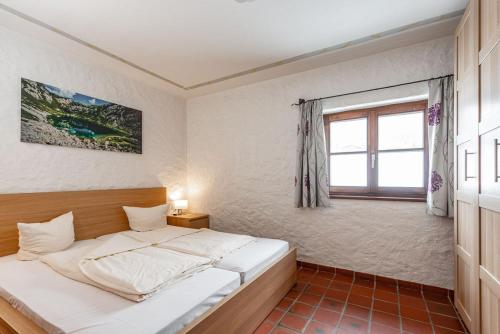 a bedroom with a bed and a window at Gästehaus Prugger by Schladmingurlaub in Ramsau am Dachstein