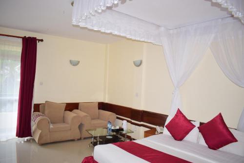 a hotel room with a bed and two chairs at Meru Slopes Hotel in Meru