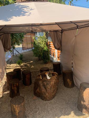 a tent with logs and a table and chairs under it at Rai pe Vale Boutique & Spa in Leordina
