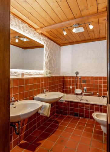 a bathroom with two sinks and a tub at Gästehaus Prugger by Schladmingurlaub in Ramsau am Dachstein