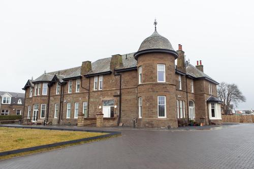a large brick building with a domed roof at Panmure Apartment in Monifieth
