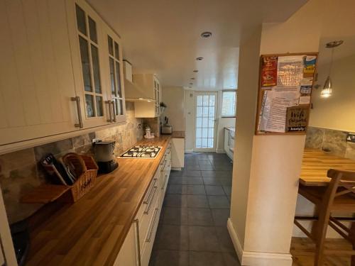 a kitchen with white cabinets and a wooden counter top at Serendipity in Broadstairs