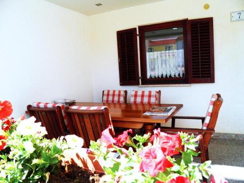 jadalnia ze stołem, krzesłami i kwiatami w obiekcie Rooms Glavan 63 w Rovinj