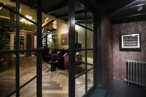 a living room with a couch and glass windows at Small Luxury Boutique Hotel Wilma J in Vinkeveen