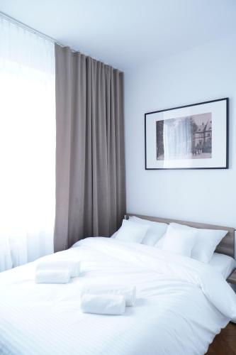 a white bed with white pillows in a bedroom at Stary Koszalin Hostel & Hotel Services in Koszalin