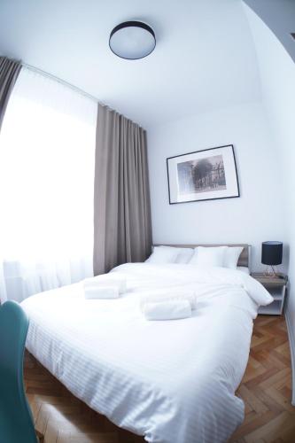 a white bed in a room with a large window at Stary Koszalin Hostel & Hotel Services in Koszalin