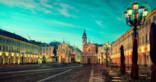 a city street with a building with a clock tower at LA CASA DEI NONNI con SPA privata su richiesta in Pont Canavese