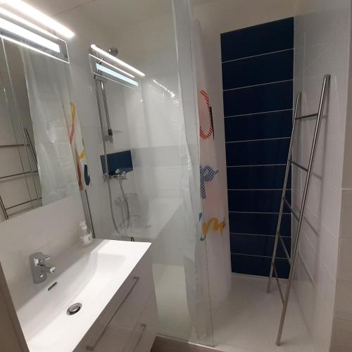 une salle de bain blanche avec une douche et un lavabo dans l'établissement Les cigales de mer, au Grau-du-Roi