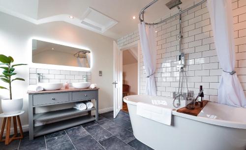 Baño blanco con bañera y lavamanos en Hilltop Country House en Macclesfield