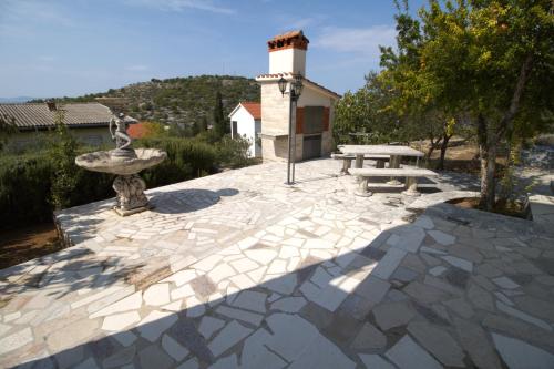 a stone patio with a fountain and a picnic table at Murter Inn in Murter