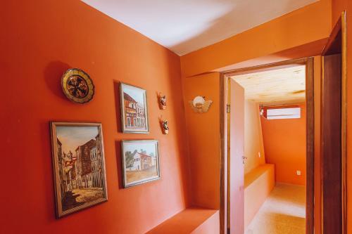 un pasillo naranja con fotos en la pared en Casas de Juan, en Morro de São Paulo