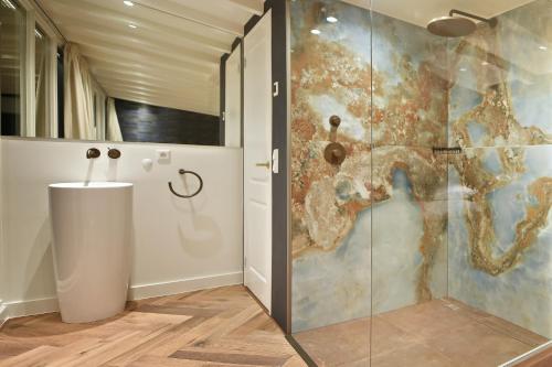 La salle de bains est pourvue d'une douche avec une porte en verre. dans l'établissement Small Luxury Boutique Hotel Wilma J, à Vinkeveen