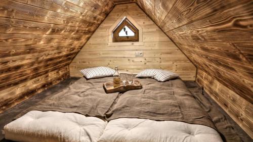 łóżko w drewnianym domku ze stołem w obiekcie Chata Baba Yaga w Zdziarze