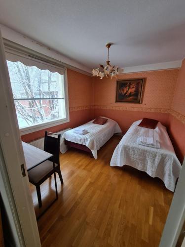 a bedroom with two beds and a window at Gasthaus Kantolankulma in Lappeenranta