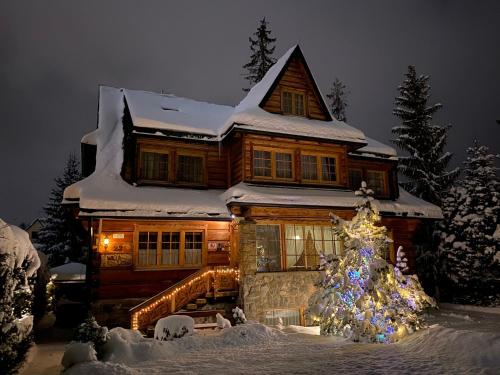 una casa con un árbol de Navidad delante de ella en Willa Leśna, en Zakopane