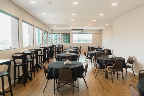 a dining room with tables and chairs and windows at Plaza Inn Trevo Sorocaba in Sorocaba