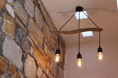 a group of lights hanging from a stone wall at Chez Kiki et Ioannis in Naxos Chora