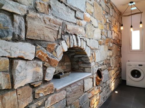 a stone wall in a laundry room with a washing machine at Chez Kiki et Ioannis in Naxos Chora