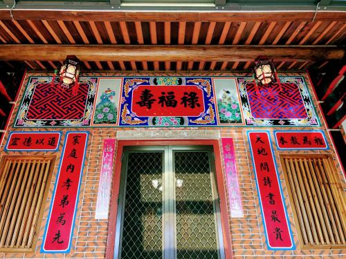 a building with signs on the front of a door at 金門后倉七號新古厝民宿 in Jinning