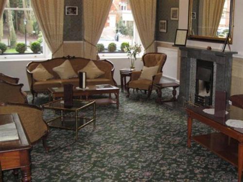 a living room with two couches and a fireplace at Canterbury Hotel Cottages and Apartment's in Canterbury