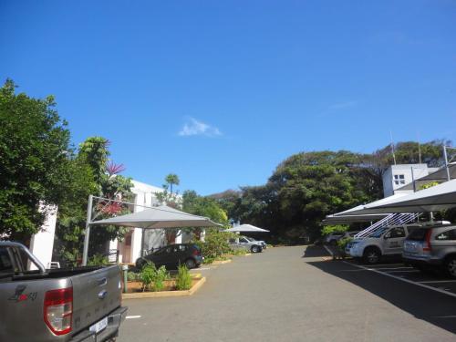 a parking lot with cars parked in front of a building at Chakas Cove in Ballito