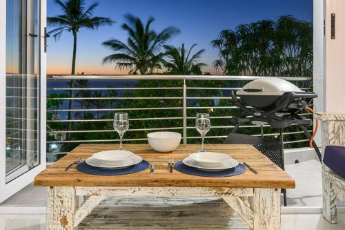 a table with two glasses and a grill on a balcony at Chakas Cove in Ballito