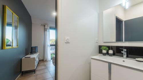 un bagno con lavandino e specchio di Plein Soleil avec Jacuzzi Privatif et parking privé a Sarlat-la-Canéda