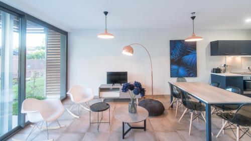 un salon avec une table et des chaises dans l'établissement Plein Soleil avec Jacuzzi Privatif et parking privé, à Sarlat-la-Canéda