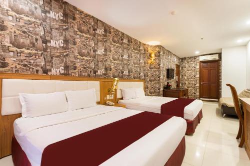 a hotel room with two beds and a wall at Lam Kinh Hotel in Ho Chi Minh City