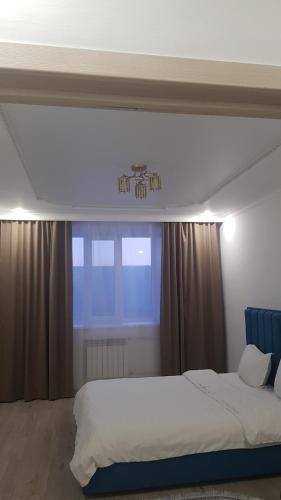una camera con un grande letto e una finestra di Аблайхана 1/3 a Kökşetaw