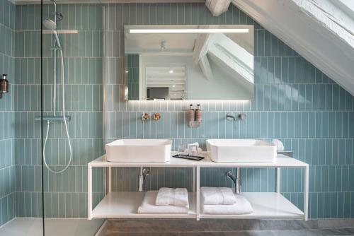 a bathroom with two sinks and a shower at Hôtel de l'Europe by HappyCulture in Strasbourg