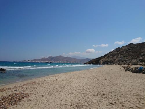 a beach with the ocean and mountains in the background at Chez Kiki et Ioannis in Naxos Chora