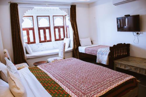 a hotel room with two beds and a window at Hotel Mewari Villa PURE VEG in Udaipur
