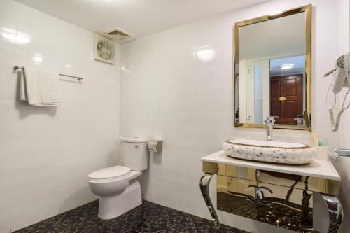 a bathroom with a toilet and a sink and a mirror at Lam Kinh Hotel in Ho Chi Minh City