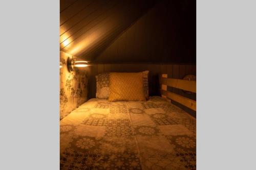 a small bedroom with a bed in a attic at The Treehouse - Sleeps 4 in Old Leake