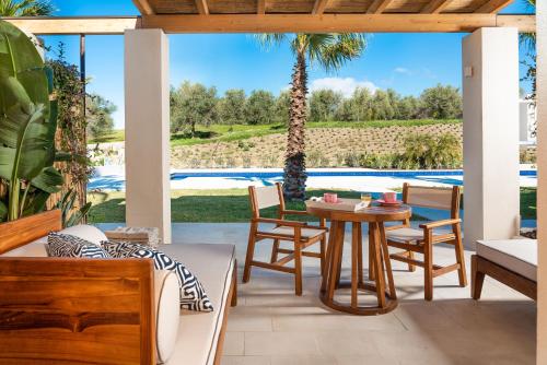 a patio with a table and chairs and a pool at Il San Corrado di Noto in Noto